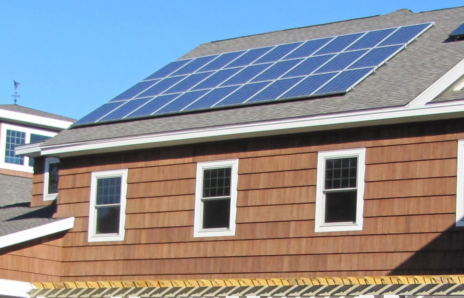 Paneles solares en el techo de una casa generando ahorro en el recibo de luz